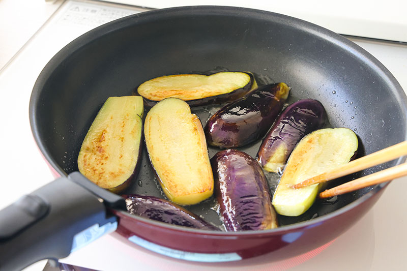 なすの生姜焼きでなすをフライパンで焼いている写真