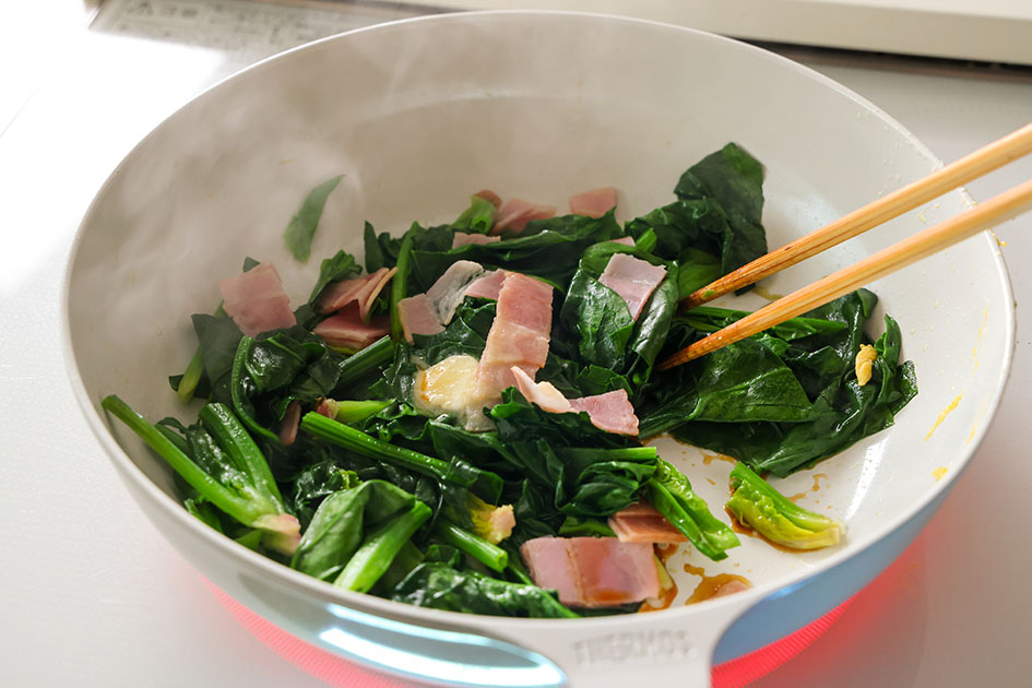 ほうれん草とベーコンの卵炒めで、ほうれん草などを炒めている写真