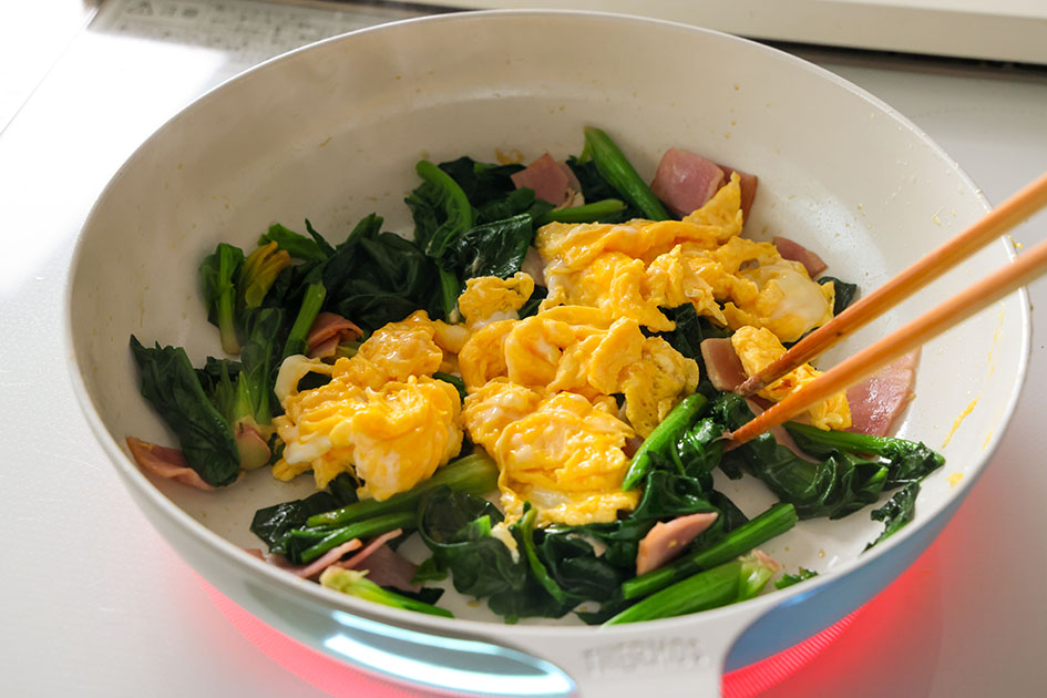 ほうれん草とベーコンの卵炒めで、最後に卵を混ぜている写真