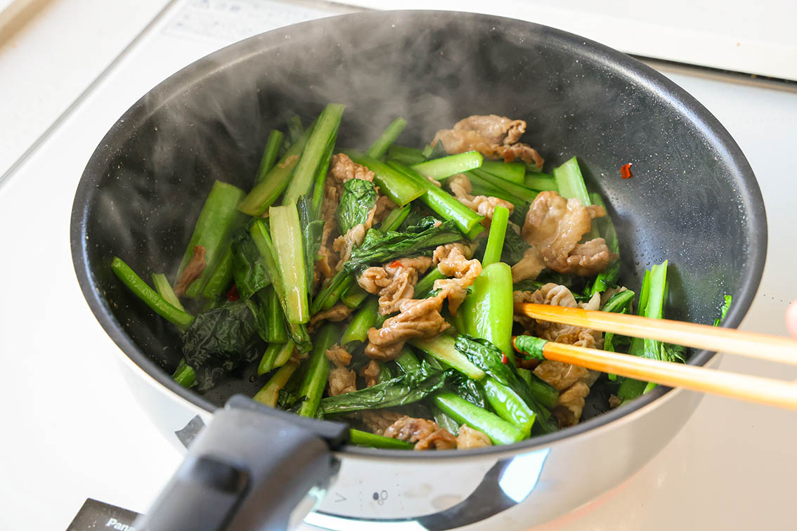 豚肉と小松菜のピリ辛中華炒めで、調味料を煮からめている写真