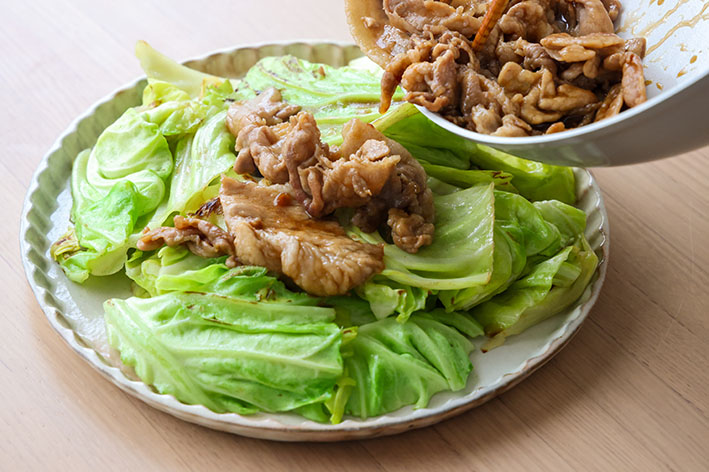 豚こまキャベツマウンテンで、味付けた豚肉をキャベツの上に盛り付けている写真