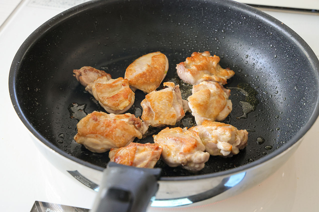 チキンとキャベツのトマト煮の材料の鶏肉を炒めている写真