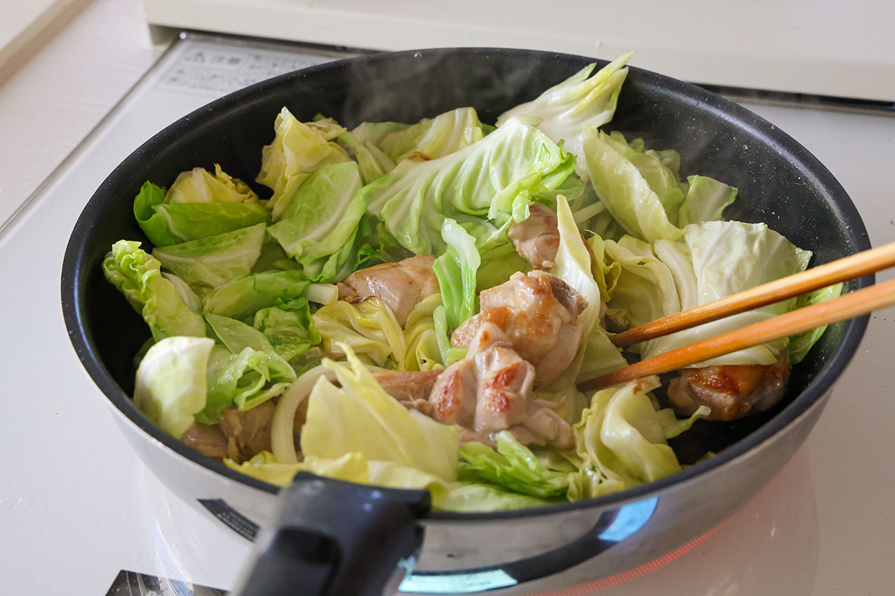 チキンとキャベツのトマト煮で、材料を炒めている写真