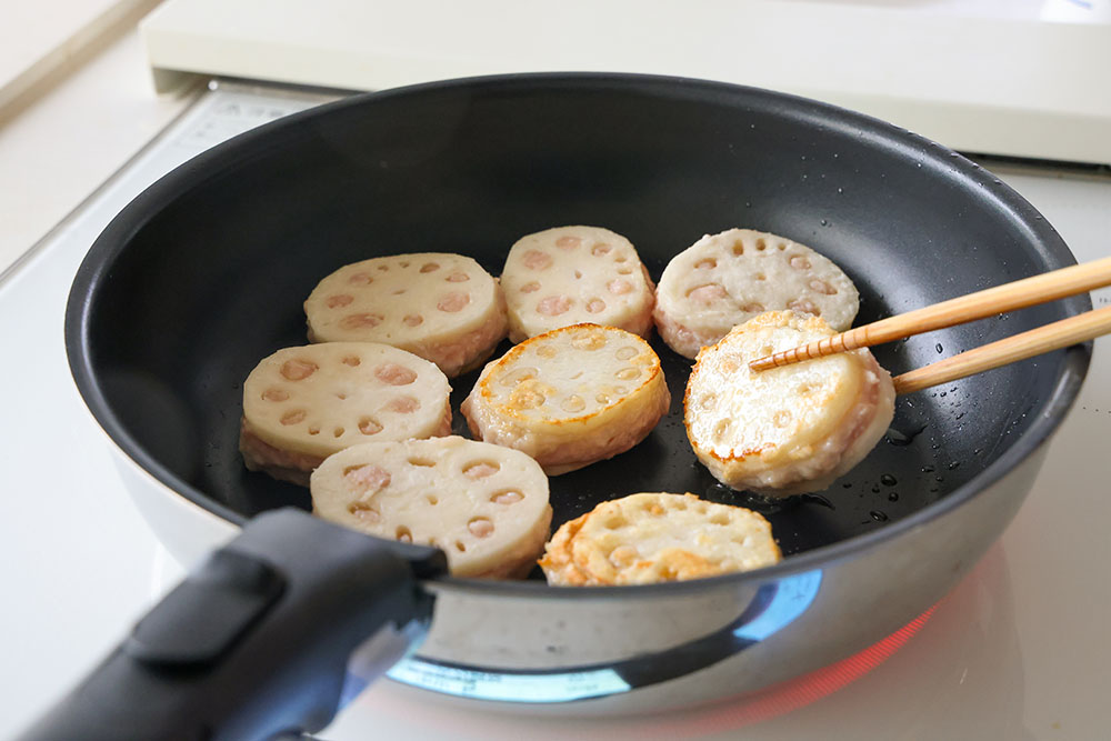 れんこんのはさみ焼きで、フライパンで焼いている写真