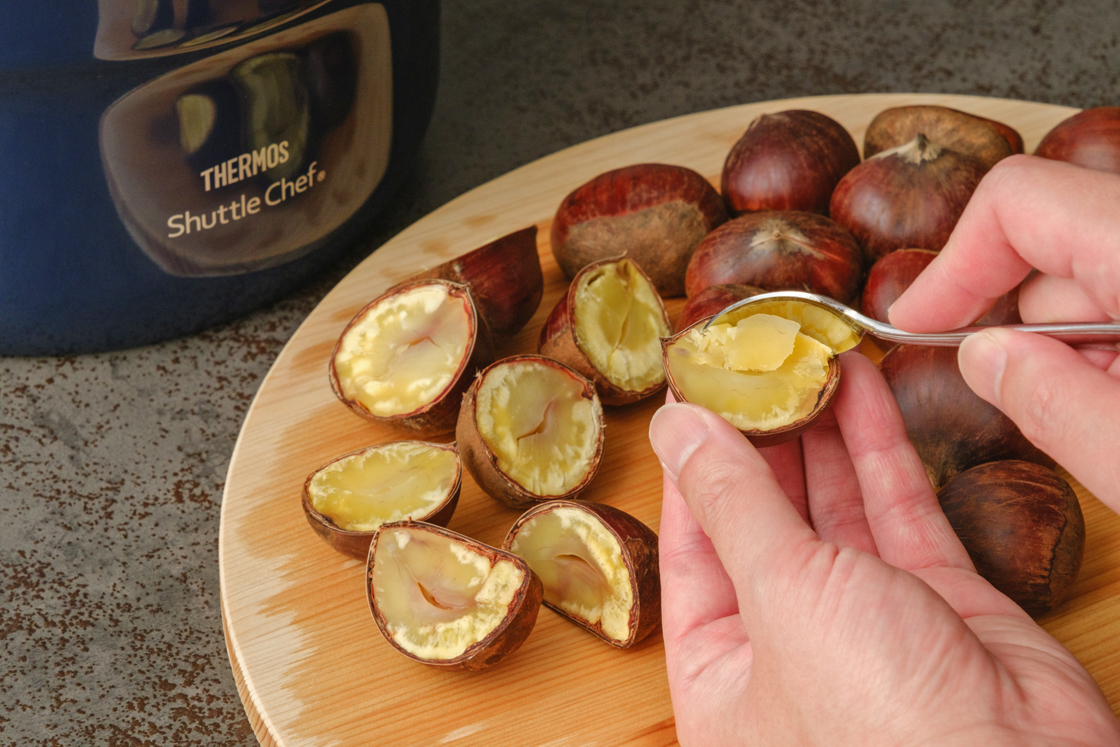 スプーンでゆで栗の中身をすくっている手元画像