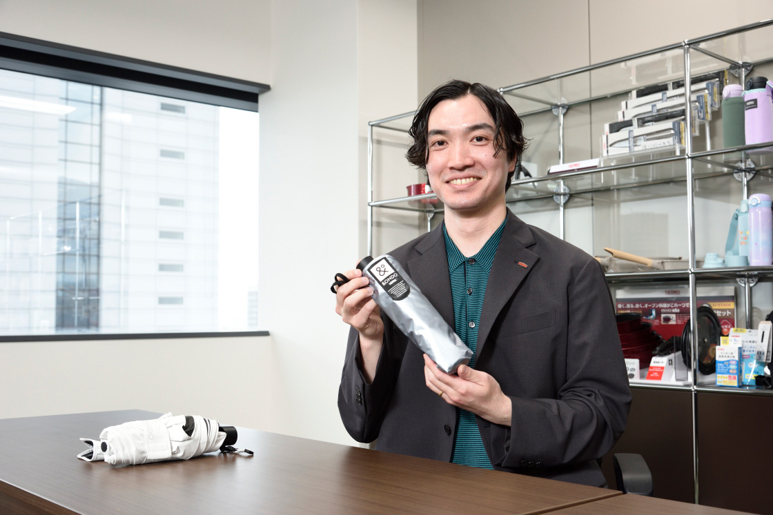 「COOL遮熱 日傘」軽量タイプ（SG-C602F）を手に取る星野さん